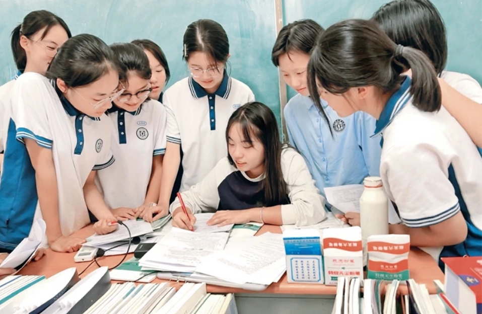 2024年10月，首届“优师计划”师范生代表张然（中）在实习时为学生进行讲解。